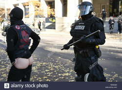 rose-city-antifa-protestor-moons-a-riot-cop-during-the-counter-protest-R2AG2M.jpg