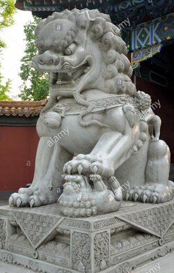 a-stone-chinese-lion-statue-standing-on-a-smaller-one-in-the-entrance-GA6T3R.jpg