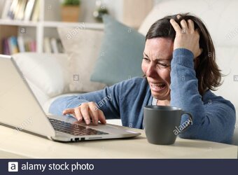 sad-adult-woman-crying-reading-bad-news-on-laptop-sitting-on-the-floor-on-a-coffee-table-at-ho...jpg