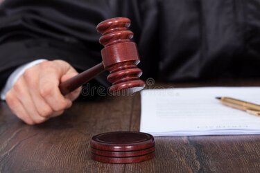 judge-giving-verdict-hitting-mallet-cropped-image-desk-43865391.jpg