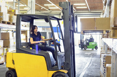 female-forklift-truck-driver-working-in-distribution-warehouse-CUF31392.jpg