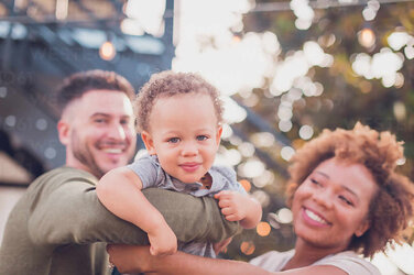 black-mom-and-white-dad-holding-baby-boy-and-playing-airplane-CAVF90351.jpg