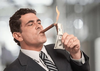 rich-businessman-lighting-cigar-100-600nw-127785641.jpg