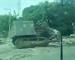 Armored-bulldozer-tank-called-Satan-side-view-destroying-houses-in-Lower-Delmas.jpg