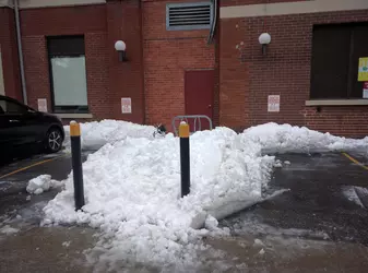 Bicycle rack barely visible under a pile of snow.