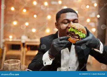 african-american-man-burger-eat-respectable-young-black-suit-gloves-food-sitting-restaurant-t...webp