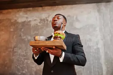 african-american-man-burger-respectable-young-black-suit-hold-tray-double-against-gray-wall-b...webp