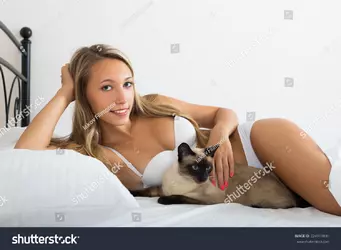 stock-photo-happy-sexy-woman-with-cat-resting-on-bed-in-the-morning-224913691.webp