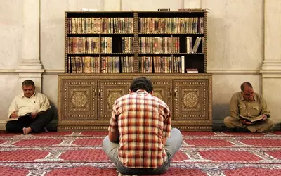 Men_reading_the_Koran_in_Umayyad_Mosque_Damascus_Syria-e1747921216700.webp