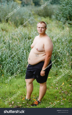stock-photo-a-very-fat-guy-without-a-shirt-is-standing-in-the-park-1353909356.webp